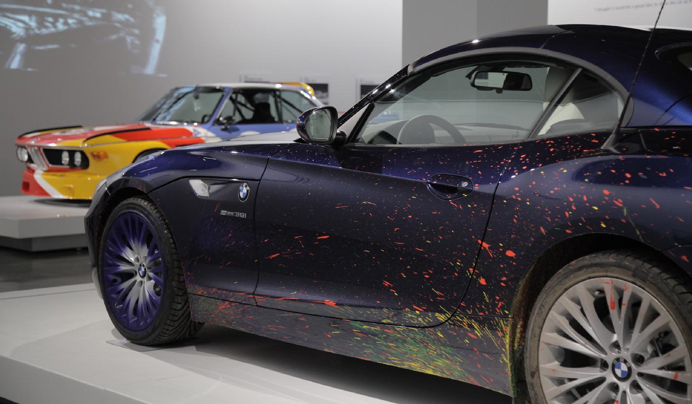  Der BMW Z4, Bauj. 2009, den der K&#xFC;nstler Robin Rhode &#xFC;ber eine riesige Leinwand fuhr (Vordergrund); und ein BMW 3.0 CSL, Bauj. 1975, bemalt von Alexander Calder, sind beides Ausstellungsst&#xFC;cke der Artistry Galerie des Museums.